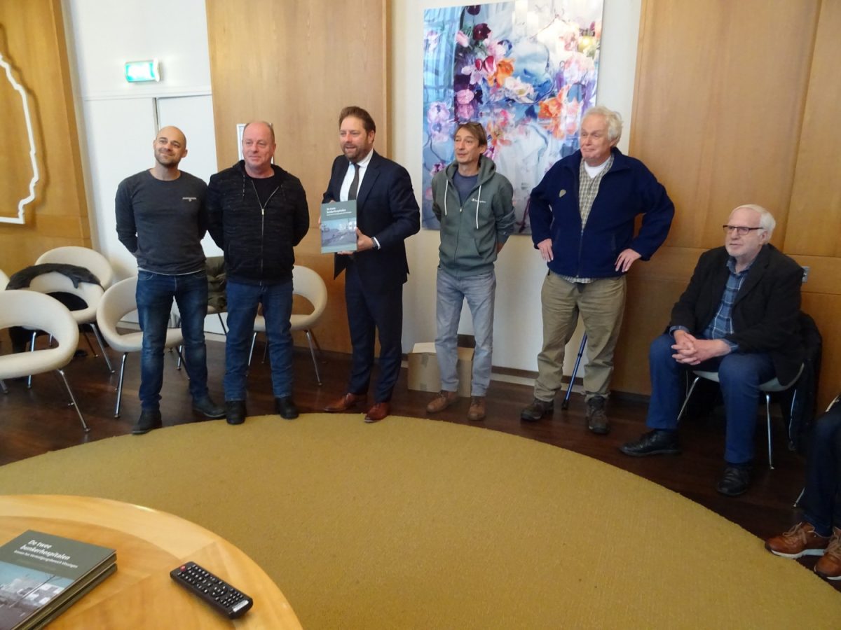 Wethouder Geoffrey Sips ontvangt het boek De twee bunkerhospitalen binnen het Verteidigungsbereich Vlissingen.